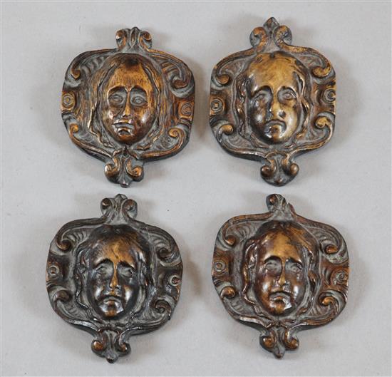 A set of four small 17th century carved walnut masks, each 4 x 3in.